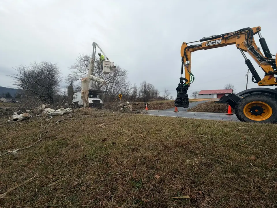Grapple saw head on the boom beside a bucket truck